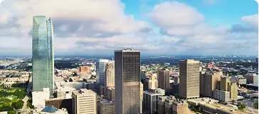 Oklahoma skyline with downtown skyscrapers beneath a partly cloudy blue sky